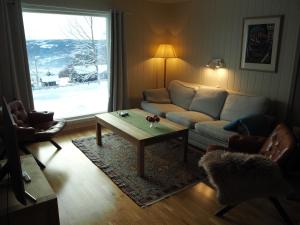 a living room with a couch and a coffee table at Cabin with great view close to town and ski area in Lillehammer