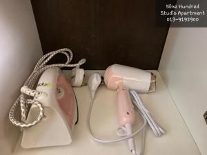 a pink hello kitty hair dryer and a pink phone at Nine Hundred Studio Apartment (KBCP) in Kota Bharu