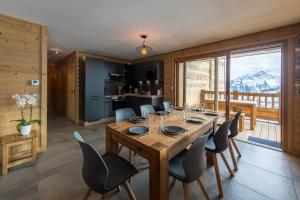 a dining room with a wooden table and chairs at ODYSSEE DRC04 Spacieux Rez de Chaussee sur les pistes in La Toussuire