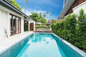 a swimming pool in the backyard of a house at NH Collection Samui Peace Resort in Bophut