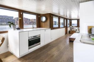 
a kitchen with a large window and a wooden floor at Stunning boat with a view in Amsterdam
