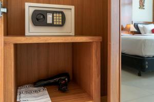 a microwave sitting on top of a shelf next to a bed at Lee Chiang Hotel in Chiang Mai