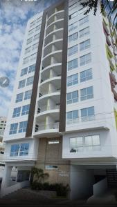 un gran edificio de apartamentos blanco con muchas ventanas en KattyApartament1102, en Salinas