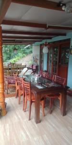 a dining room with a large wooden table and chairs at Damsen Homestay Ella in Ella