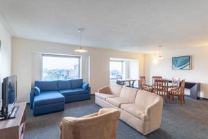 a living room with a blue couch and a table at Holiday Inn Guadalajara Expo Plaza del Sol by IHG in Guadalajara
