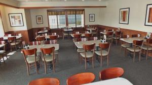 a restaurant with tables and chairs in a room at Holiday Inn Hotel & Suites Regina, an IHG Hotel in Regina