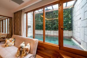 a living room with a large window and a swimming pool at The Radh Hotel in Kandy