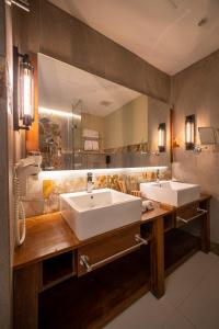 a bathroom with a sink and a large mirror at The Radh Hotel in Kandy