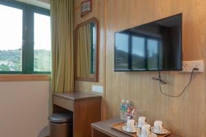 a bathroom with a tv on a wall with a sink at Hotel Rose Crest Hill, Cameron Highland in Tanah Rata
