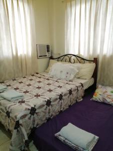 1 dormitorio con 1 cama con edredón en Cranberry's Place-near CONVENTION center en Iloilo