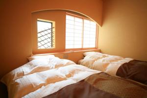 A bed or beds in a room at Wafu no Yado Masuya