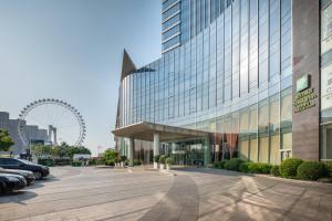 un gran edificio con un estacionamiento delante de él en Holiday Inn Tianjin Riverside, an IHG Hotel, en Tianjin