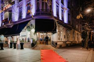 un tappeto rosso di fronte a un edificio di notte di Le Grand Hotel a Valenciennes