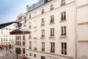 パリにあるCentral Luxury Louvre Opera 2nd Floorの窓と通りがある白い建物