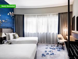 a hotel room with two beds and a desk at Copthorne King's Hotel Singapore on Havelock in Singapore