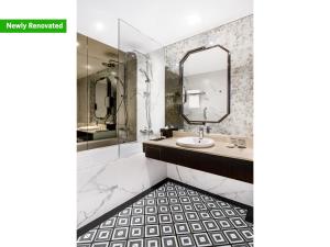 ein Bad mit einem Waschbecken und einem Spiegel in der Unterkunft Copthorne King's Hotel Singapore on Havelock in Singapur