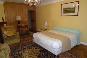 - une chambre avec un lit, une chaise et un canapé dans l'établissement Chambres d'Hôtes à la Fontanille, à Panazol