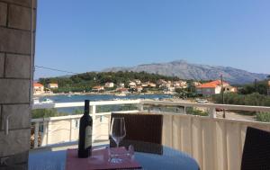Una botella de vino sentada en una mesa en un balcón en Villa Laguna, en Lumbarda