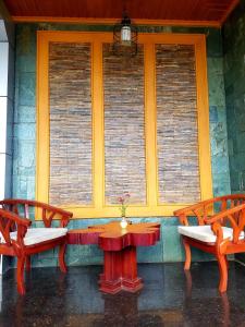 a porch with two benches and a table and two windows at Shwe Kyun Hotel in Taunggyi