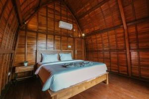a bedroom with a bed in a wooden room at The Palms Canggu in Canggu