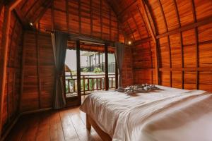 a bedroom with a bed and a large window at The Palms Canggu in Canggu
