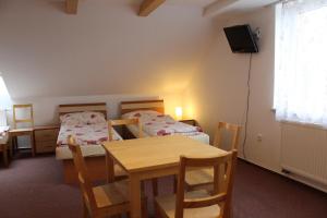 a room with two beds and a table and a television at Penzion Na Devitce in Světnov