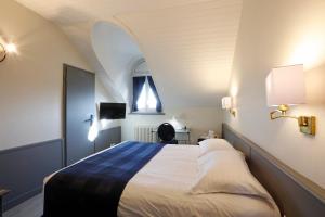
a bedroom with a bed and a lamp at Hotel Montbrillant in Geneva
