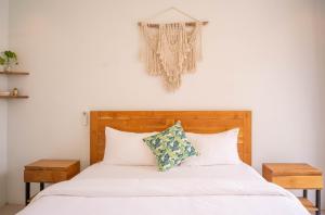 a bedroom with a bed with white sheets and pillows at The Palms Canggu in Canggu