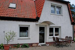 une maison avec une table et des chaises devant elle dans l'établissement Ferienwohnungen auf dem Pommernhof, à Samtens