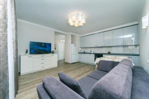 a living room with a couch and a tv at Лучшая квартира в Броварах in Brovary