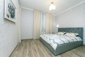 Un dormitorio con una cama azul y una ventana en Лучшая квартира в Броварах en Brovary