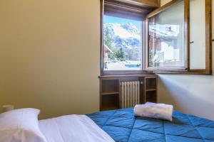 sypialnia z łóżkiem i oknem z widokiem w obiekcie Cantore, Cortina by Short Holidays w mieście Cortina dʼAmpezzo