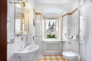 a bathroom with a sink and a toilet and a window at Hotel Lippert in Prague