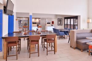 una sala da pranzo e una cucina con un grande tavolo e sedie di Holiday Inn Express Hotel & Suites Farmington, an IHG Hotel a Farmington