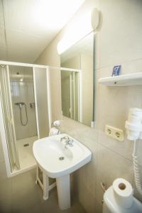 a bathroom with a sink and a shower and a mirror at Hotel Teruel in Vinaròs