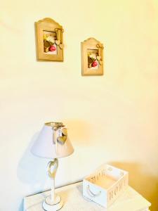 lampa na stole obok ściany z dwoma zdjęciami w obiekcie The Stone Garden w mieście Noto