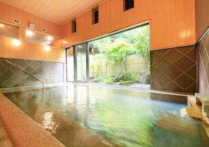 einen Pool in einem Haus mit einem großen Fenster in der Unterkunft Saikatei Jidaiya in Kaminoyama