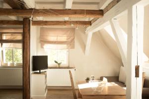 a dining room with a table and a tv at moments café & apartmenthaus in Thurnau