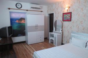 a bedroom with a bed and a desk and a television at KHÁCH SẠN HƯƠNG SEN PHÚ YÊN in Tuy Hoa