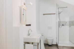 a white bathroom with a sink and a shower at Villa Breitenberg in Breitenberg