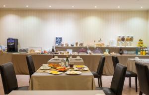 a restaurant with tables and chairs with food on them at Hotel Andria in La Seu d'Urgell