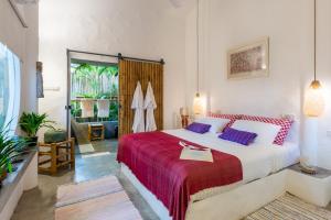 a bedroom with a large bed with a red blanket at DHYANA VILLAS in Hinkong