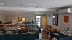 a restaurant with two tables and a counter in a room at Arena Hotel (formerly Sleep Express Motel) in Sydney