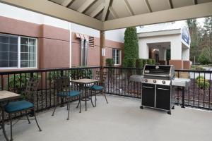 un patio esterno con barbecue, tavoli e sedie di Candlewood Suites Olympia - Lacey, an IHG Hotel a Lacey