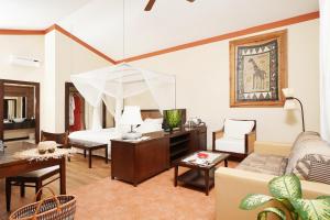 a living room with a bed and a couch at Diamonds Dream of Africa in Malindi