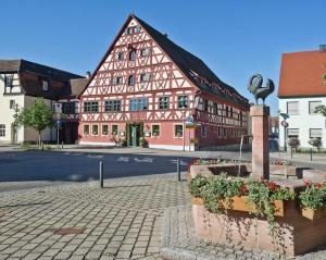 a large red and white building with flowers in front of it at DER SCHWAN Hotel & Restaurant in Schwanstetten