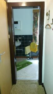 a bathroom with a yellow chair and a sink at Ferienwohnung Hünefeld in Weimar