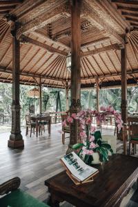 - un pavillon avec une table et des fleurs dans l'établissement Bucu View Resort, à Ubud