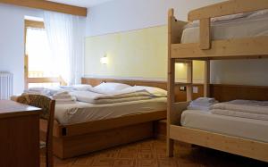 Letto o letti a castello in una camera di Alpen Hotel Rabbi
