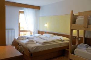 um quarto com 2 beliches e uma mesa em Alpen Hotel Rabbi em Rabbi